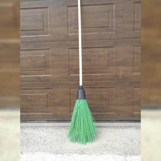 Plastic Broom sweeps the house wet foliage, snow, dirt garden street 
